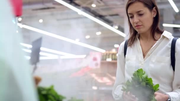 Свежие органические травы в супермаркете, женщина берет салат зелень с полок — стоковое видео