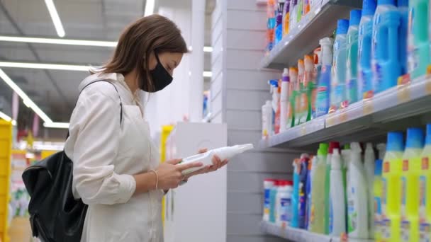 Женщина-покупатель выбирает чистящие средства в отделе бытовой химии — стоковое видео