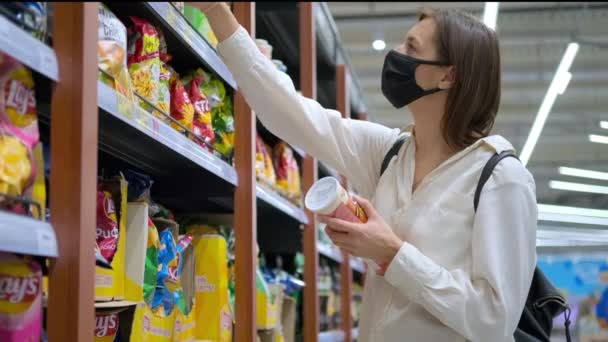 Rosja, Soczi- 20 grudnia 2020: młoda klientka robi zakupy w hipermarkecie i bierze dwie paczki żetonów — Wideo stockowe