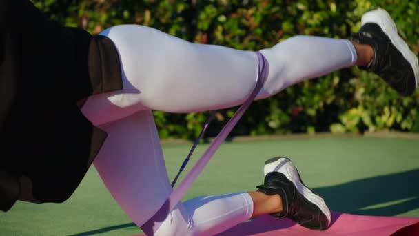 Jonge sportvrouw hief been omhoog tijdens het sporten in het park — Stockvideo