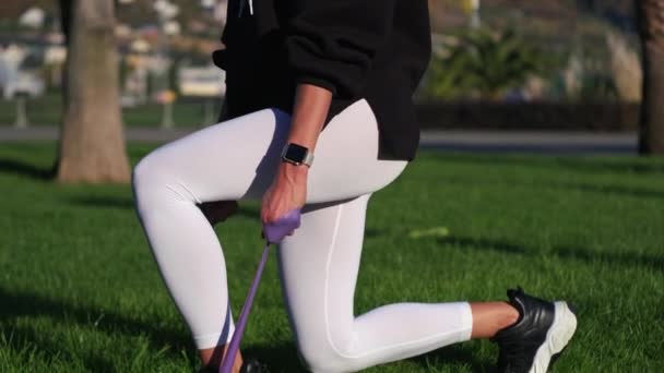 Entrenamiento deportivo de la joven mujer delgada, en cuclillas con cinta — Vídeos de Stock