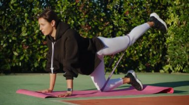 Sportif kadın parkta tek başına bantla antrenman yapıyor.