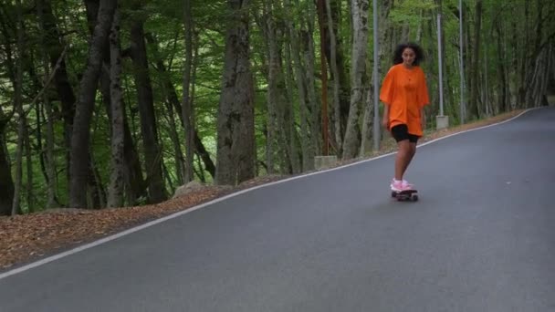 Sportief brunette skateboarden op de parkway — Stockvideo