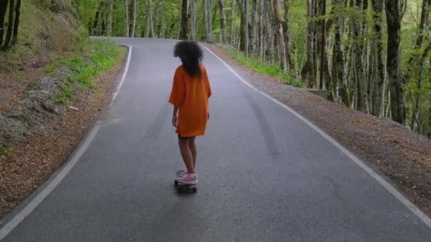 Meisje skateboarden in schilderachtig hout — Stockvideo