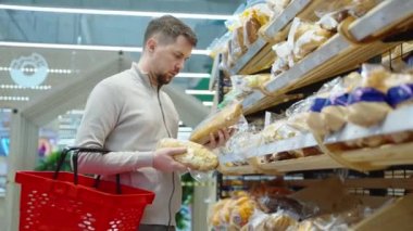 Adam kahvaltıda ekmek alıyor, markette taze yiyeceklerle alışveriş yapıyor.