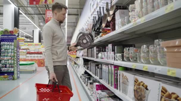 L'homme veut acheter une poêle à frire dans un magasin de produits ménagers — Video