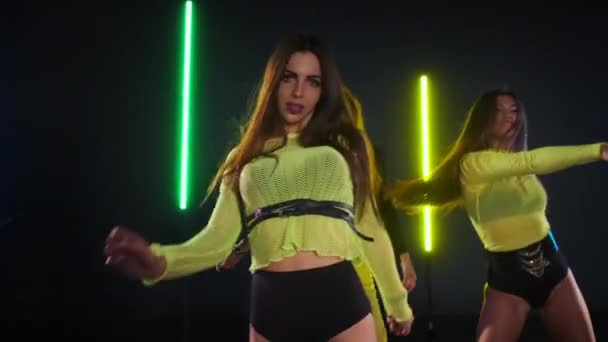 Kreativa kvinnliga dansare band utför sexig go-go dans i studio med neonljus — Stockvideo