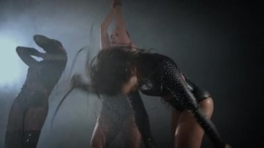 Striptizci kadınlar gece kulübünde çoraplarla dans ediyor.