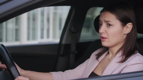 Wypadek samochodowy w mieście, emocjonalna kobieta siedzi w samochodzie, bojąc się i płacząc — Wideo stockowe
