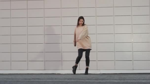Słodkie miasto mieszkaniec kobieta jest taniec przed płytki ściany w mieście, komfortowy styl casual — Wideo stockowe