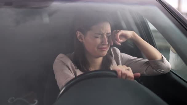 Mulher solitária está chorando dentro do carro, sentado no assento do motorista, vista através do pára-brisa — Vídeo de Stock