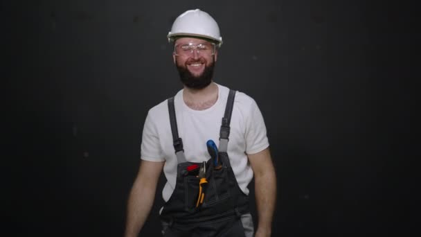 Улыбающийся мастер по ремонту в защитном шлеме и очках — стоковое видео