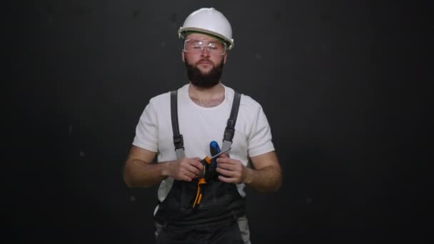 Werknemer met schroevendraaier in het algemeen tegen zwart — Stockvideo