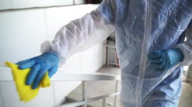 Dezenfekte servisi koronavirüsten kamu alanlarını tedavi ediyor, işçiler tırabzanları siliyor