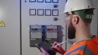 Elektrikçi fabrikadaki ölçümleri alıyor.