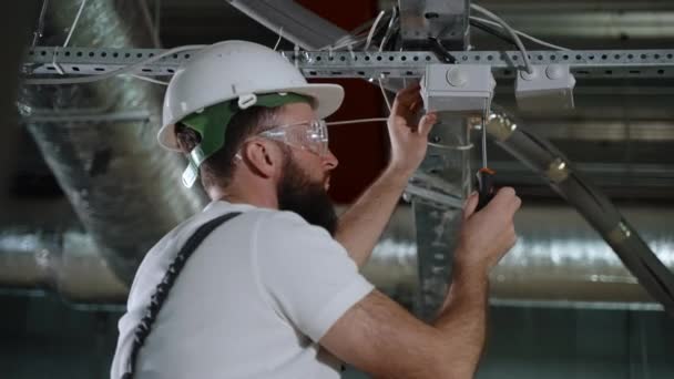 Electricien installant la boîte de jonction. Travaux de câblage électrique — Video