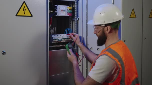 Elektriker überprüft elektrische Spannung im Schaltschrank per Multimeter — Stockvideo