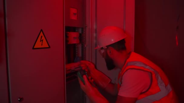 Elektricien werkt in rood alarm licht — Stockvideo