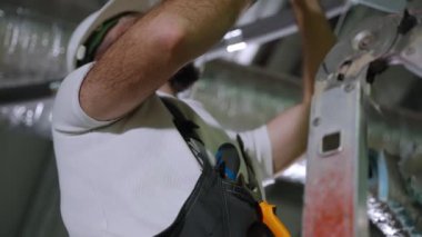 İşçi fabrika atölyesinde ekipman onarıyor