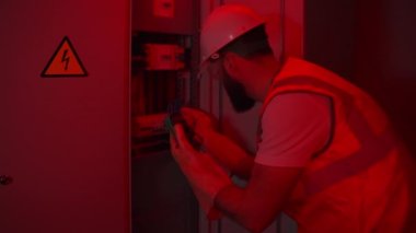 Endüstriyel kaza, elektrikçi elektrik panelinin bozulmasını tamir ediyor.