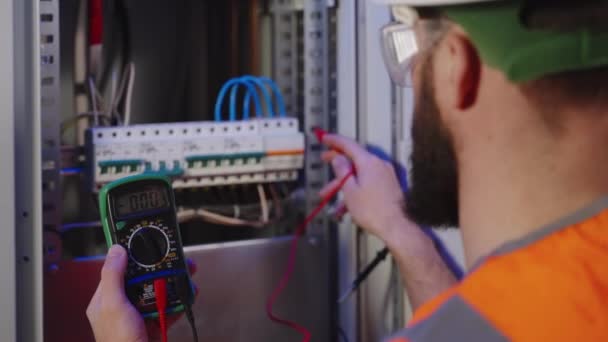 Electricista usando multímetro para comprobar la centralita — Vídeos de Stock