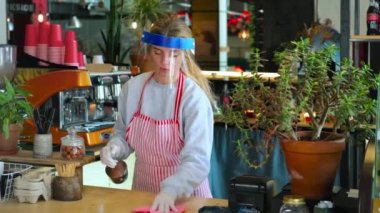 COVID 19 salgınında restoranda dezenfeksiyon ve hijyenik normlar var. Barmen kadın, bar tezgahını dezenfektanla siliyor.