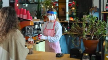 Kadın paket kahve alıyor, Salgın 'da akıllı telefondan ücretsiz ödeme.