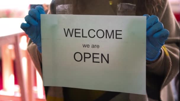 Café se abre después de cuarentena Covid-19, trabajador con guantes está poniendo inscripción, Bienvenido estamos abiertos — Vídeo de stock