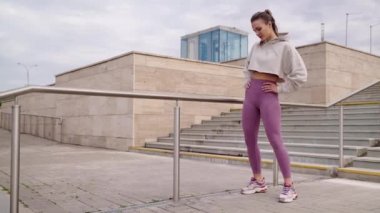 Şehirde sabah antrenmanı, genç sporcu bayan fiziksel egzersiz yapıyor.