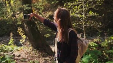 Bayan turist yolculuk sırasında akıllı telefondan selfie çekiyor.