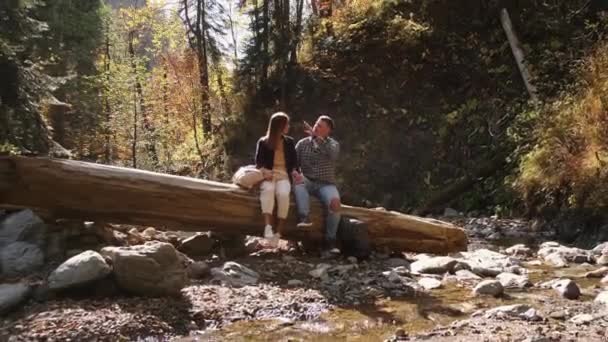 Erkek ve kız arkadaşı sonbahar günü ormanda dinleniyorlar. — Stok video