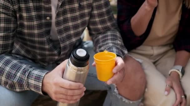 Fermarsi in escursioni, uomo e donna stanno bevendo il tè dalla fiaschetta thermos — Video Stock