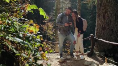 Sonbahar güneşli bir günde iki turist güzel ve pitoresk bir doğal parkı ziyaret ediyor.