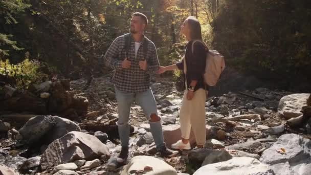 Любящая пара осенью исследует лес, путешествуя на природе — стоковое видео