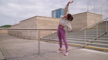 Kadın ayakta eğiliyor. Isınma egzersizleri