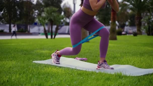 Femme est la formation pour garder une bonne forme du corps et perdre du poids, séance d'entraînement avec bande élastique — Video