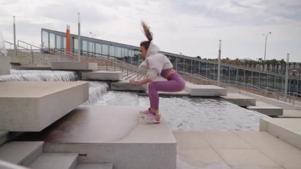 Training in de stad, jonge vrouw springt over grote trappen, ochtend oefening — Stockvideo