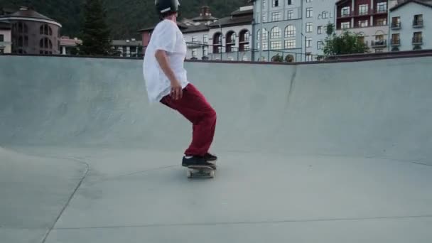 Скейтбординг в спеціальному парку, спортсмен їде скейтборд в міському парку — стокове відео