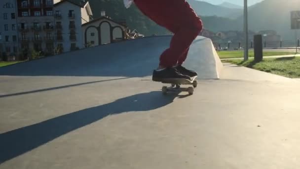 Skateboarder montar en skatepark en la luz del sol brillante — Vídeo de stock