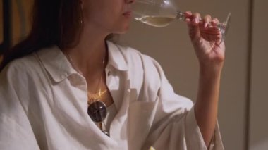 Genç kadın beyaz şarap tadıyor.