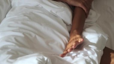 Sabah uyandığında, yatakta yatan genç bir kadının ellerinin ayrıntıları.