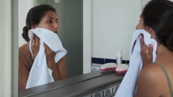 Mujer mirándose en el espejo y limpiando la cara después de lavarse por la mañana — Vídeo de stock