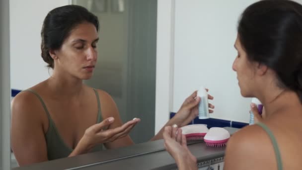 Donna che si prende cura della pelle del viso e applica la crema — Video Stock