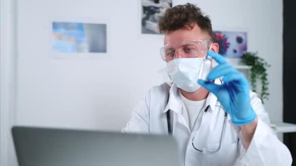 Καθηγητής ιολογίας δείχνει φιαλίδιο με νέο φάρμακο από τον ιό σε απευθείας σύνδεση συνέδριο — Αρχείο Βίντεο