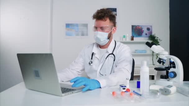 Dipendente maschio del laboratorio di ricerca medica sta lavorando in ufficio, riempiendo il risultato del test nel database — Video Stock