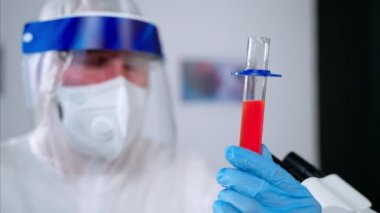 Bilim adamı araştırma sonucu test tüpüne bakıyor.