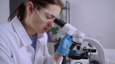 Mikroskopla çalışan mikrobiyoloji araştırmacısı.