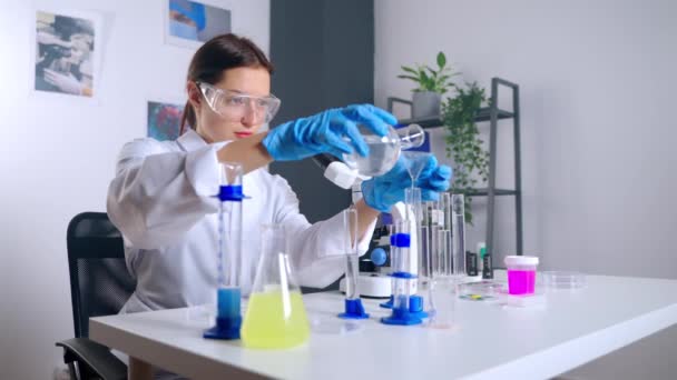 여성 과학자가 화학 실험실에서 실험하고 있다 — 비디오