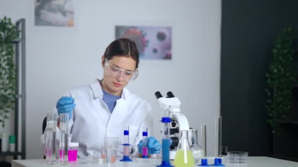 Chemist student woman is doing laboratory test, examining and exploring samples of substances — Stock Video