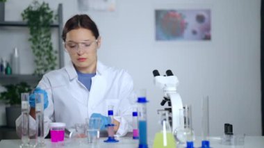 Laboratuvarda mikrobiyolojik araştırma, kadın çalışan örnekleri mikroskop altında inceliyor